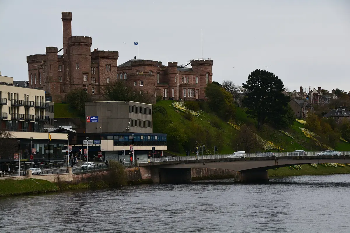 Inverness Castle, a red sandstone building with towers, above the River Ness and a road bridge